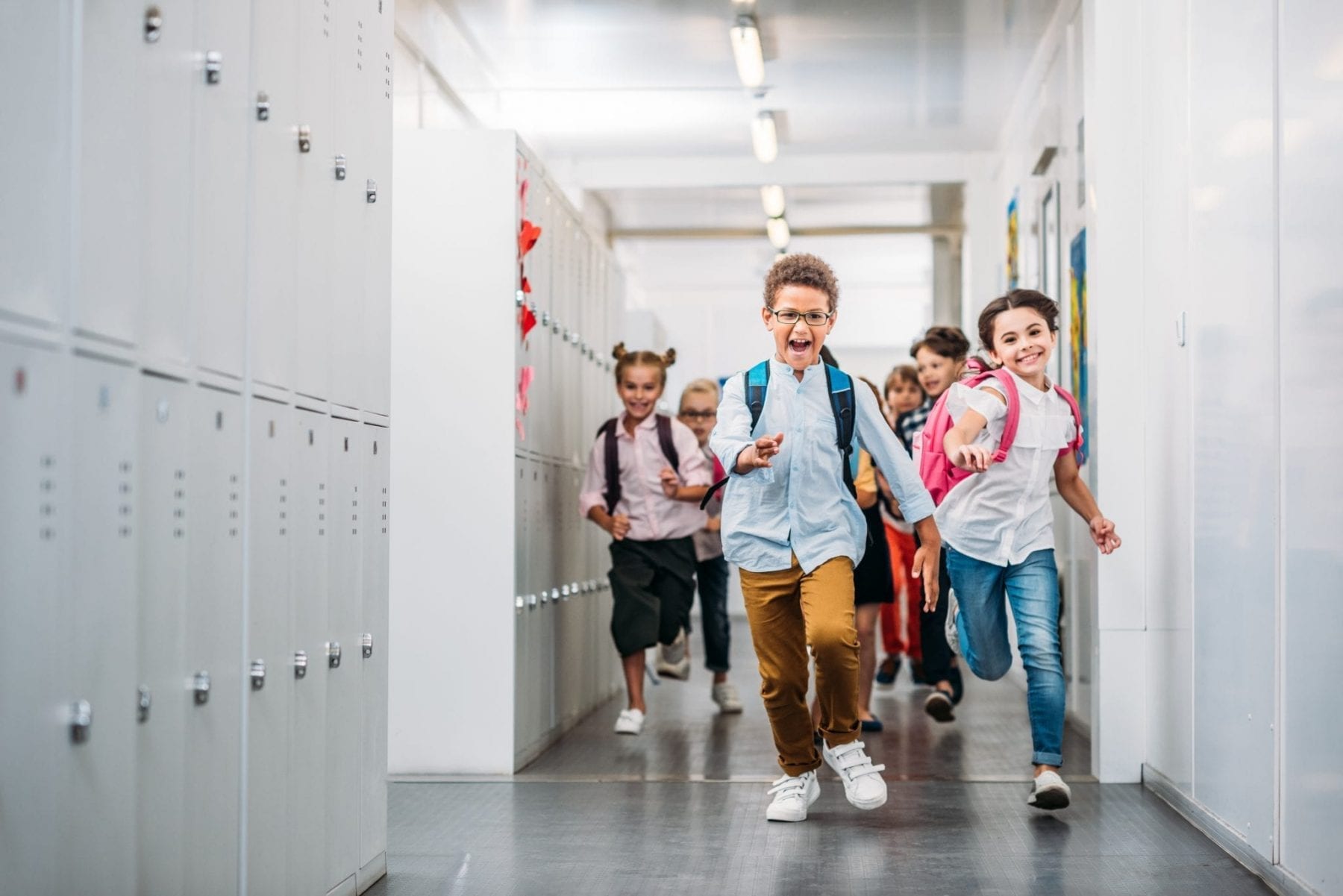 Students running through school corridor