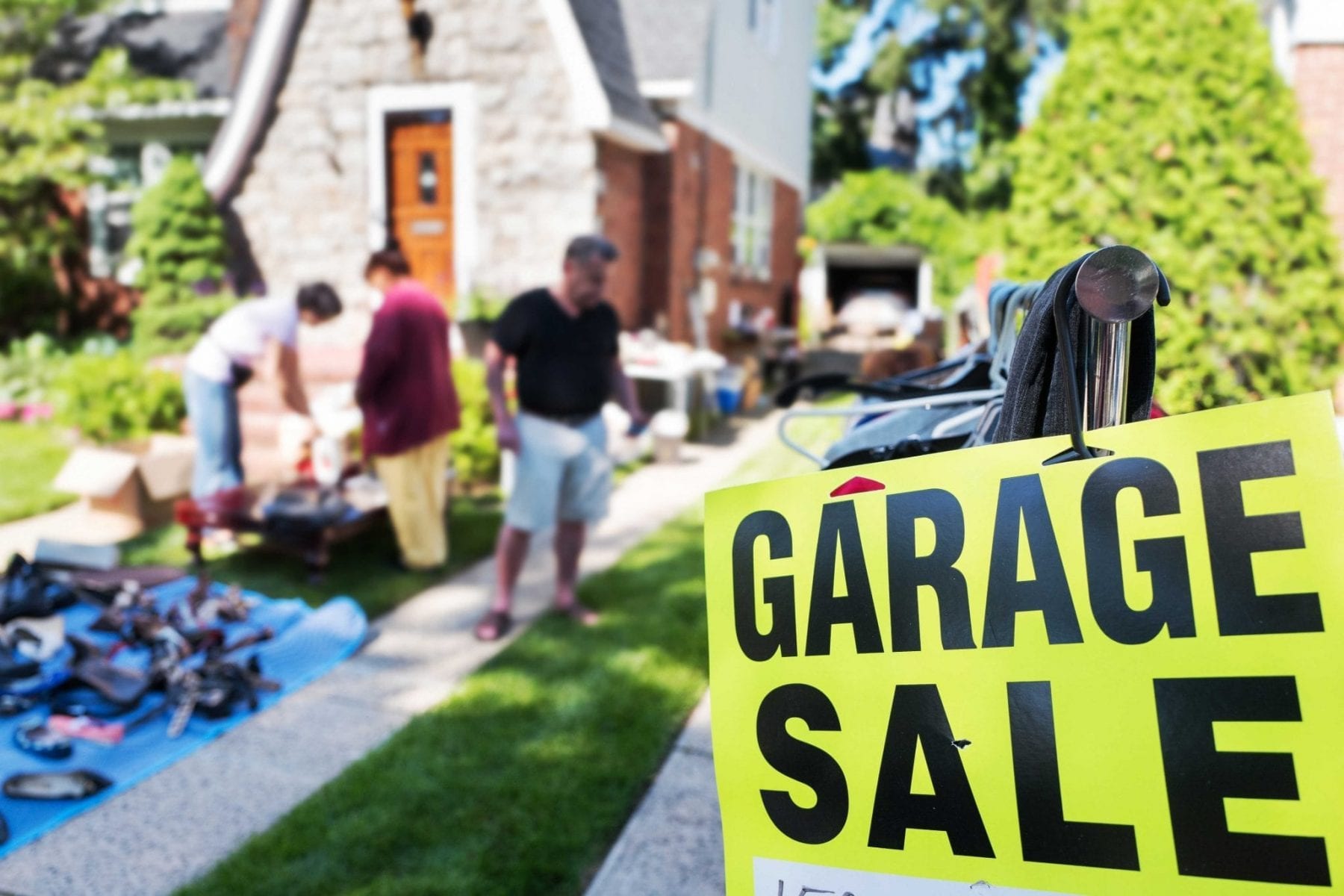People at garage sale outside with sign up front