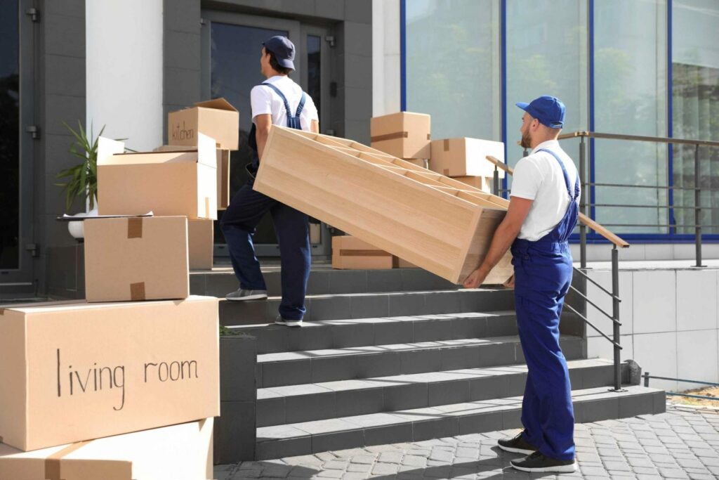 2 movers moving furniture into building