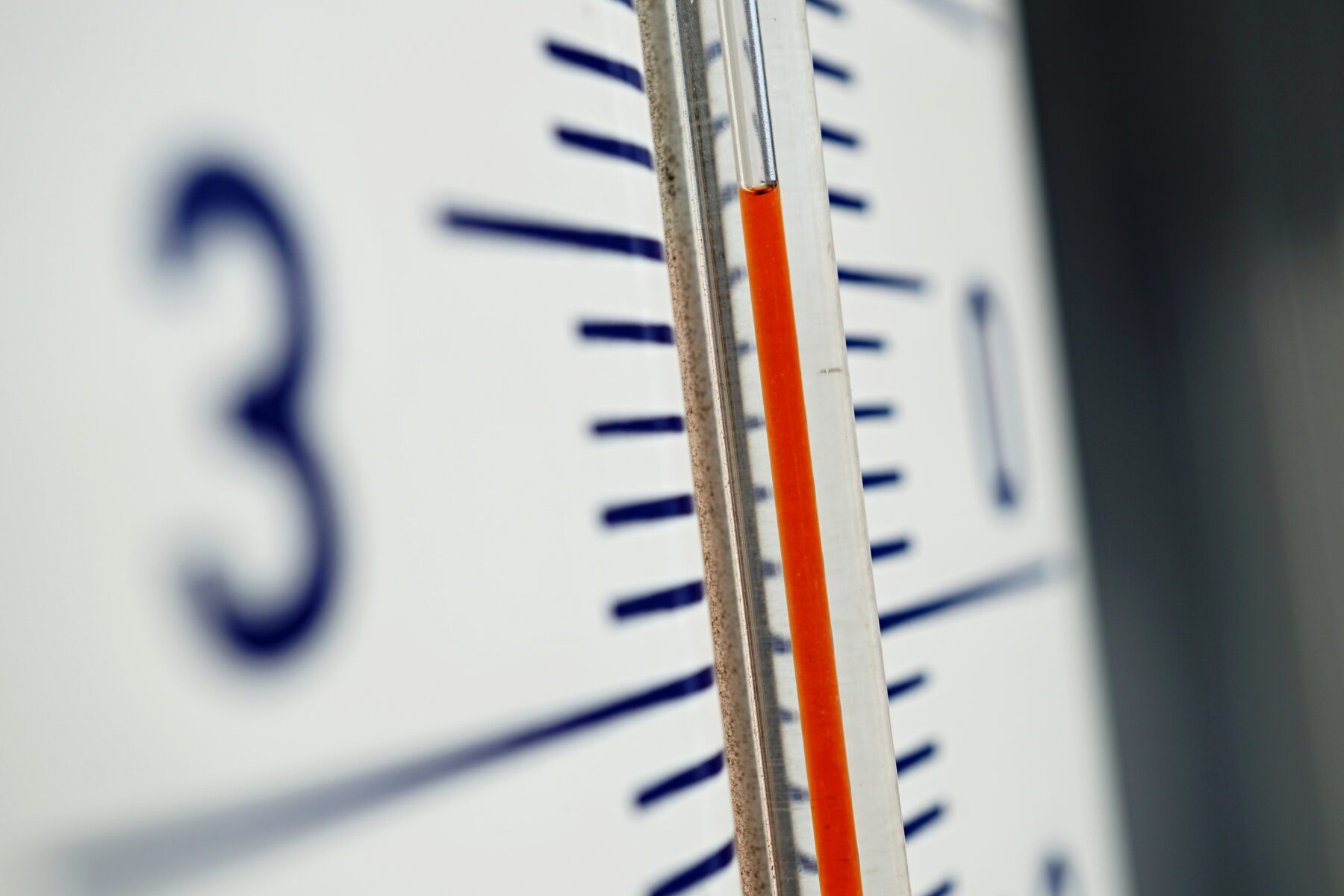 Very close up image of a thermometer showing rising temperatures