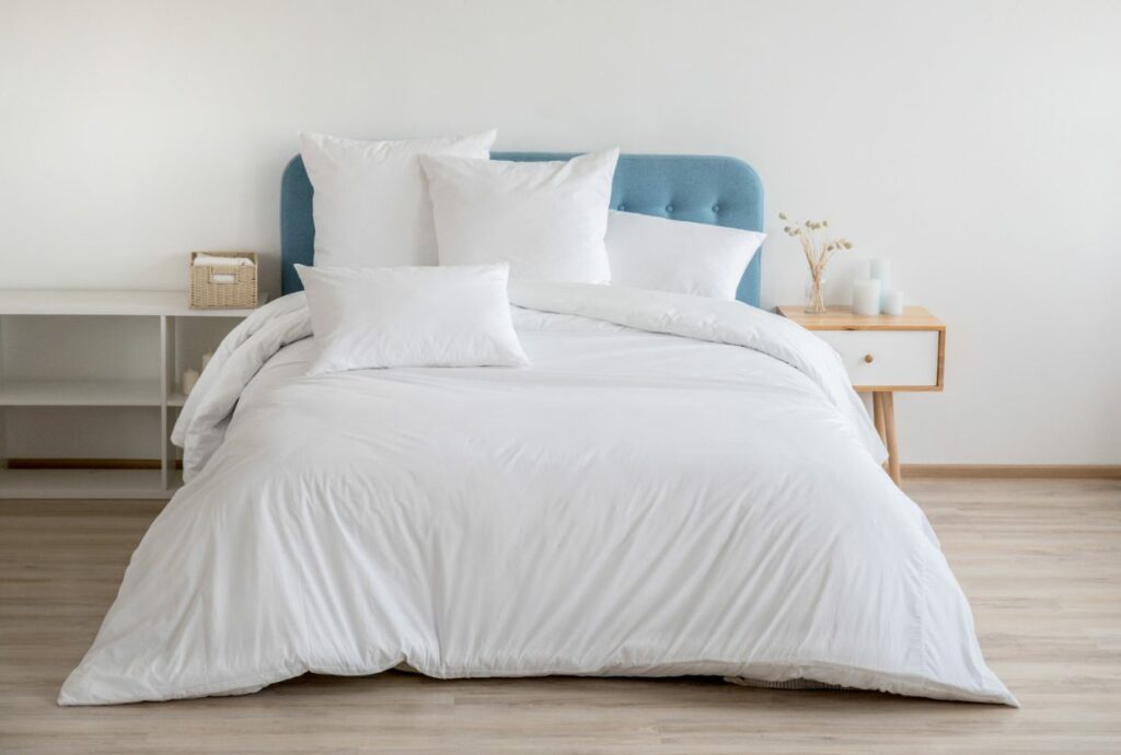 Large fluffy white bed with blue headboard