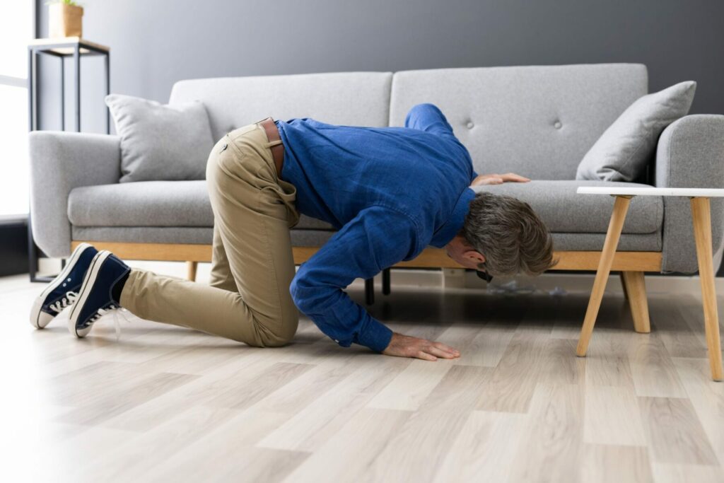 Man searching under a couch