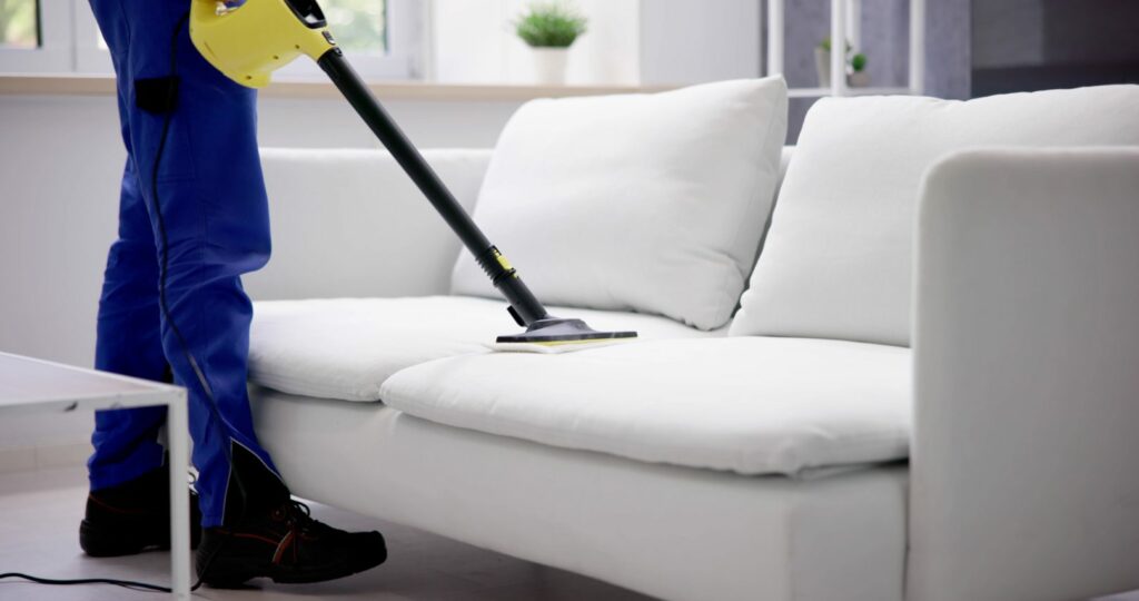 person using a steamer on a couch